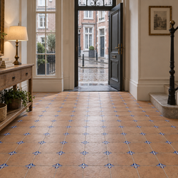 Belgische inkomhal met terracottakleurige keramische vloertegels van 22,5 × 22,5 cm en blauwe hoekmotieven